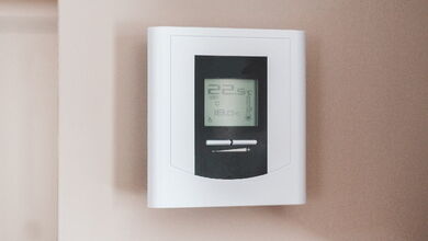 Ein digitales Wandthermostat, welches die Raumtemperatur anzeigt.