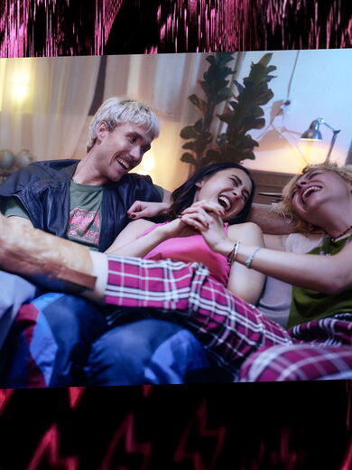 Freunde sitzen lachend auf einem Sofa