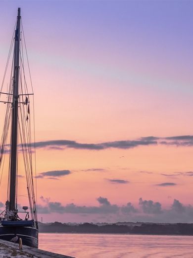 Dämmerung in Kiel mit einem angelegten Segelschiff