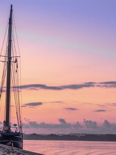 Dämmerung in Kiel mit einem angelegten Segelschiff