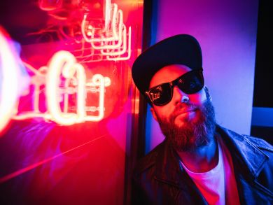 Ein Mann mit Sonnenbrille Ein Mann mit Sonnenbrille und Mütze sitzt an einem Fenster.