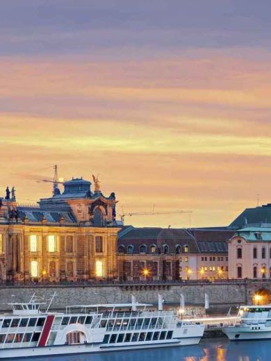 Ein Ufer in Dresden mit der erleuchteten Oper im Hintergrund
