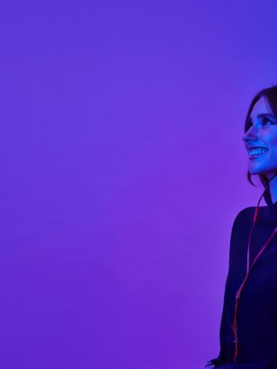 Eine lächelnde Frau mit Kopfhörer auf