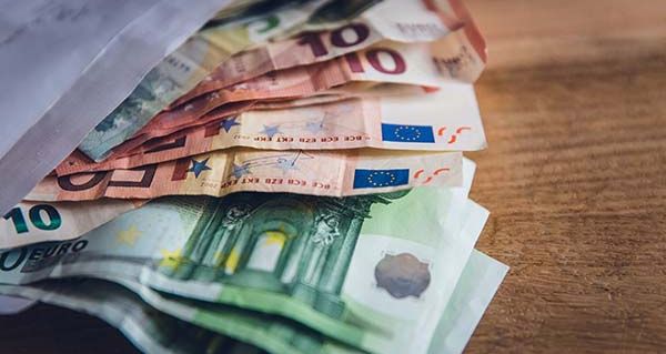100€, 50€, 10€ und 5€ Scheine ragen aus einem Briefumschlag.