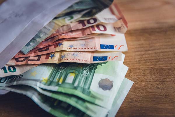 100€, 50€, 10€ und 5€ Scheine ragen aus einem Briefumschlag.